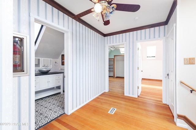 hall featuring sink, wood-type flooring, and ornamental molding