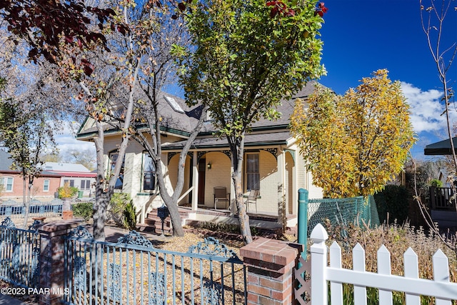 view of property hidden behind natural elements with covered porch