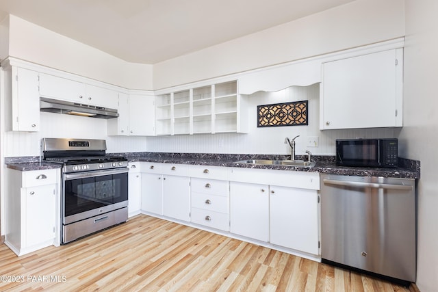 kitchen with appliances with stainless steel finishes, light wood-type flooring, and white cabinetry