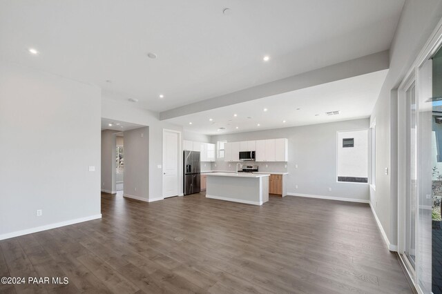 unfurnished living room with plenty of natural light and dark hardwood / wood-style floors