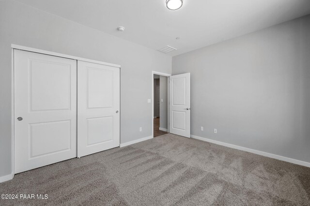 unfurnished bedroom featuring carpet and a closet