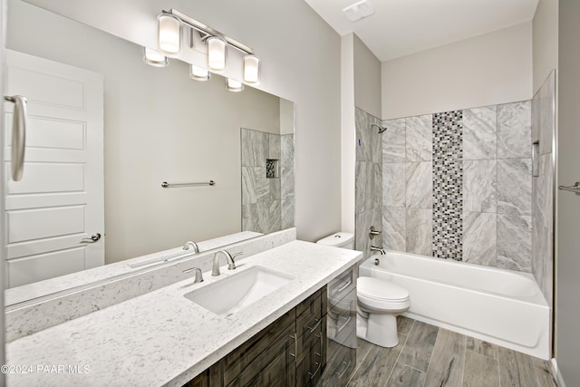 full bathroom featuring wood finished floors, visible vents, shower / bath combination, toilet, and vanity
