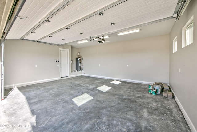 garage with a garage door opener, electric water heater, and baseboards