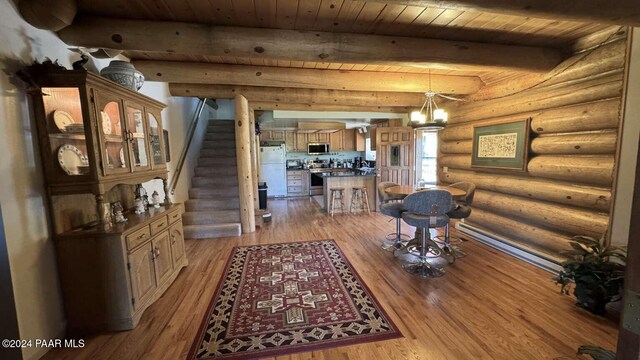 interior space with beam ceiling, light wood-type flooring, an inviting chandelier, and wooden ceiling