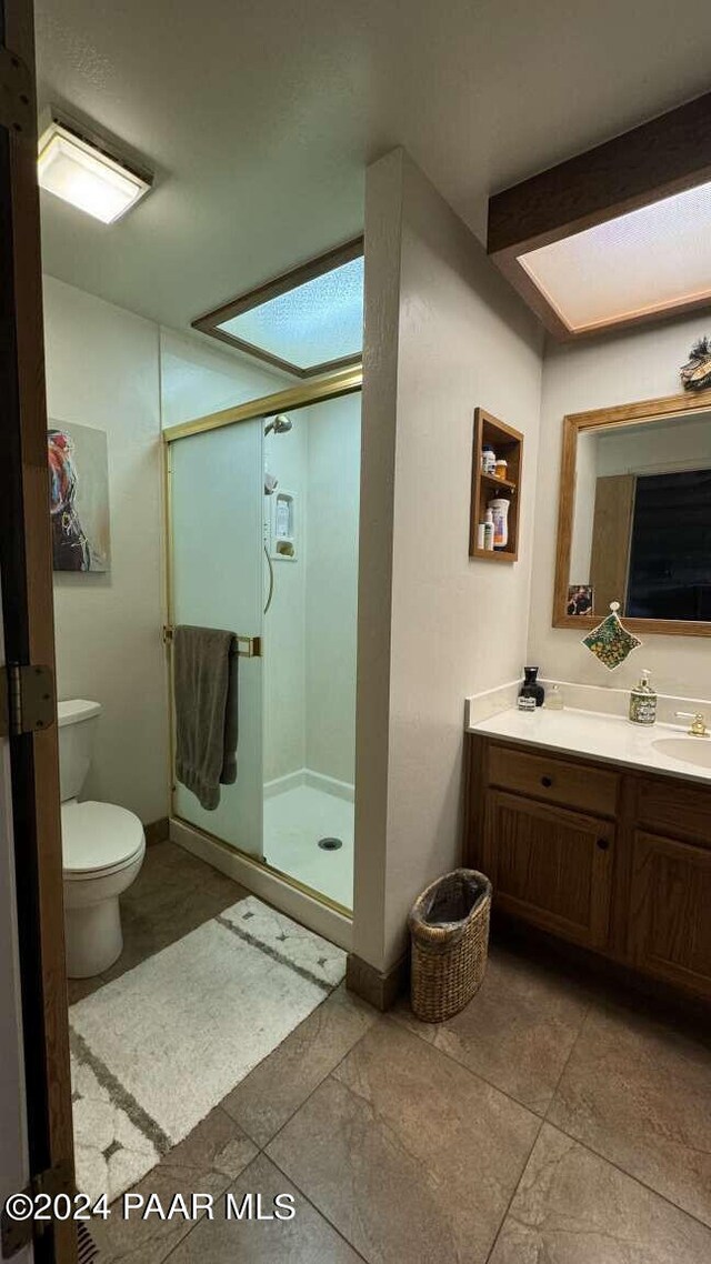 bathroom with vanity, toilet, and a shower with shower door