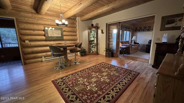 interior space with hardwood / wood-style floors, rustic walls, beamed ceiling, a notable chandelier, and wood ceiling