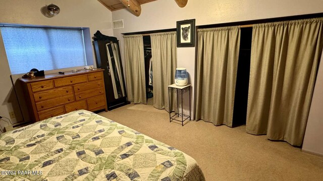 bedroom featuring lofted ceiling with beams and light colored carpet