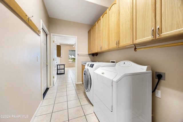 laundry area featuring light tile patterned flooring, cabinets, and independent washer and dryer