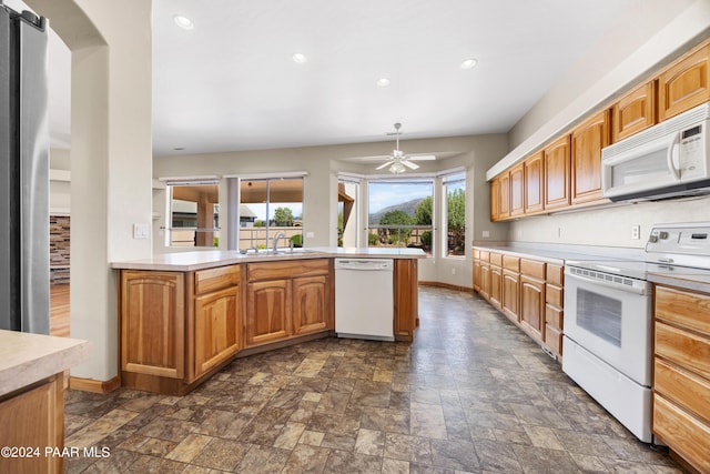 kitchen with a barn door, ceiling fan, sink, and white appliances