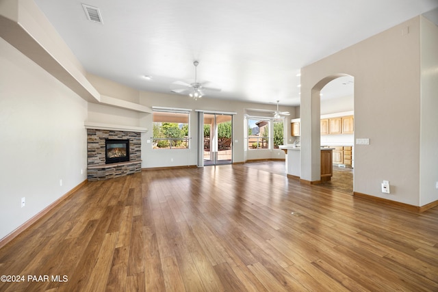 unfurnished living room featuring a fireplace, ceiling fan, and hardwood / wood-style floors