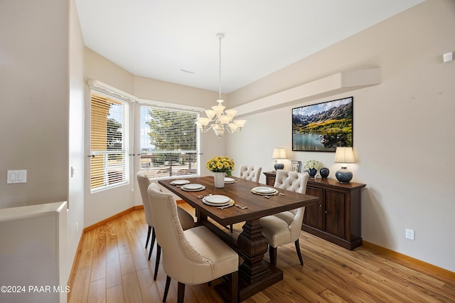 dining room with light hardwood / wood-style floors and an inviting chandelier