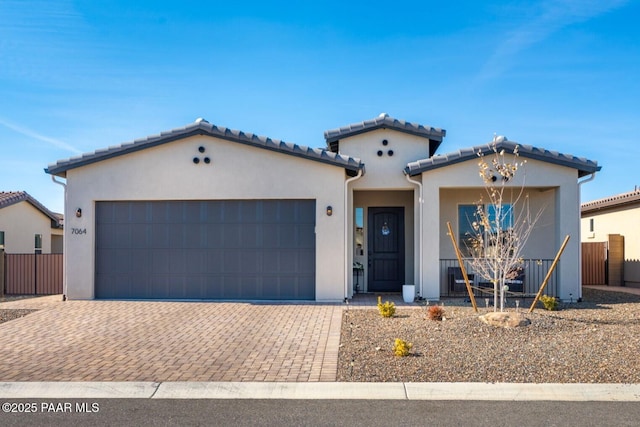 7064 N Robin Nest Ct, Prescott Valley, AZ 86315 - mediterranean / spanish house with stucco siding, a garage, a tile roof, and decorative driveway