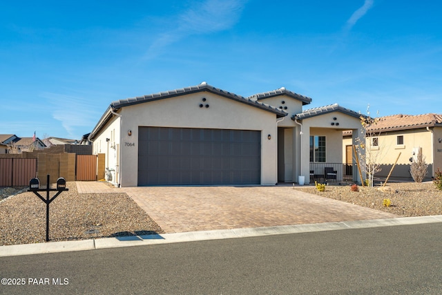 7064 N Robin Nest Ct, Prescott Valley, AZ 86315 - mediterranean / spanish home featuring an attached garage, stucco siding, driveway, a tiled roof, and a gate