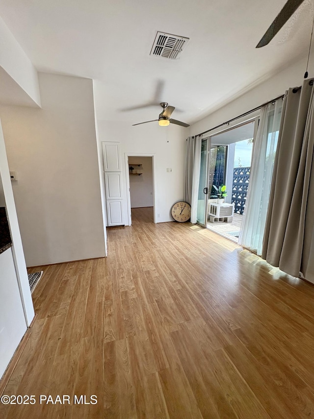 interior space featuring ceiling fan, light wood finished floors, and visible vents
