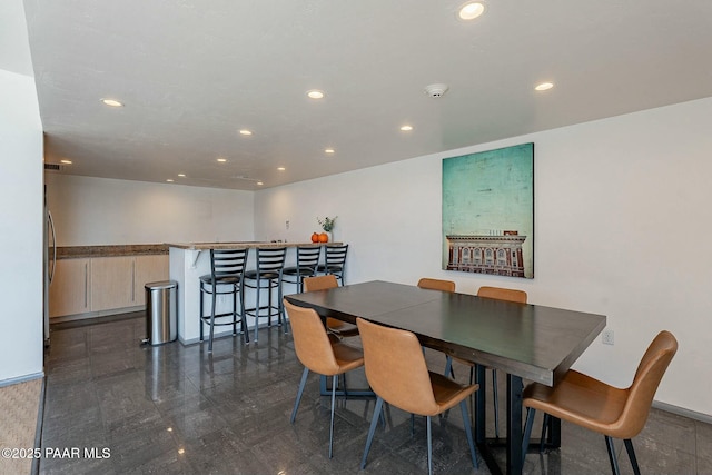 dining space featuring a bar, baseboards, and recessed lighting