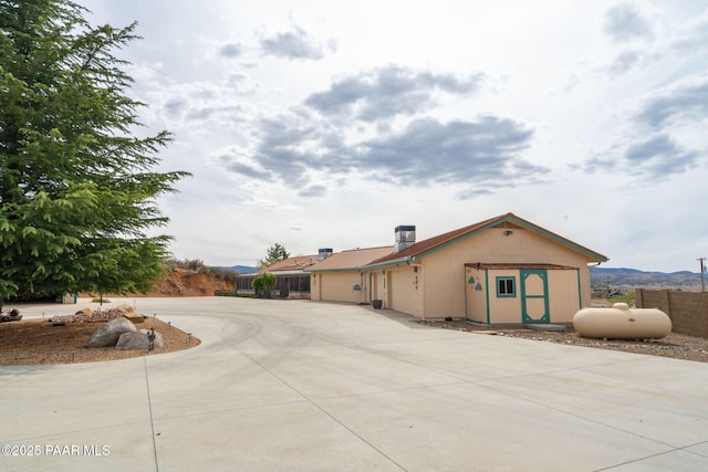 14705 E State Route 169, Dewey-Humboldt, AZ 86327 - rear view of property featuring fence, curved driveway, an attached garage, and an outbuilding