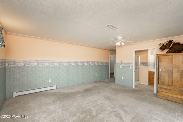 14705 E State Route 169, Dewey-Humboldt, AZ 86327 - unfurnished bedroom featuring a baseboard heating unit, wainscoting, carpet flooring, wallpapered walls, and a textured ceiling