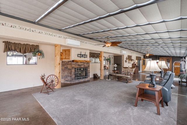 14705 E State Route 169, Dewey-Humboldt, AZ 86327 - living room with a wall mounted air conditioner, finished concrete floors, a stone fireplace, and ceiling fan