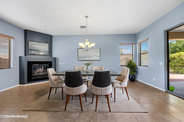 dining space with plenty of natural light, a glass covered fireplace, visible vents, and baseboards