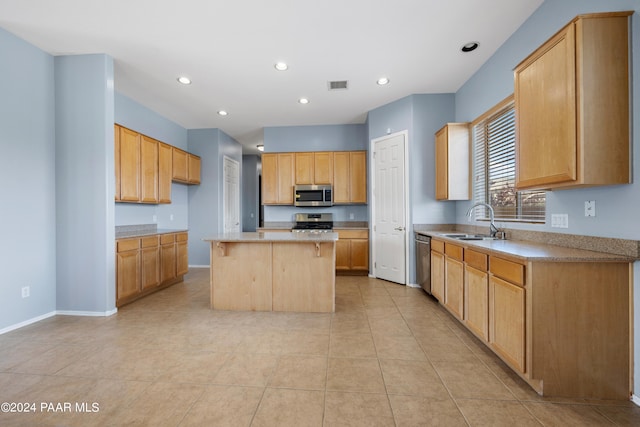 kitchen featuring stainless steel appliances, a center island, light countertops, and a sink