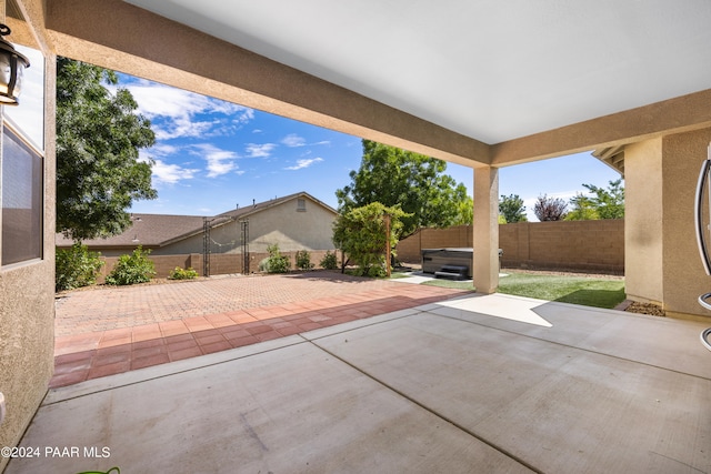 view of patio / terrace with a fenced backyard and a hot tub