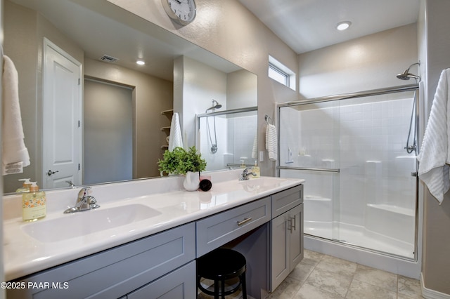 bathroom with visible vents, a shower stall, and a sink