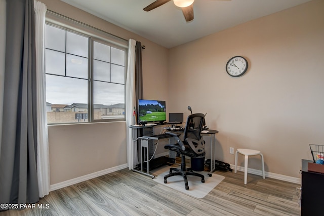 home office with a ceiling fan, wood finished floors, and baseboards