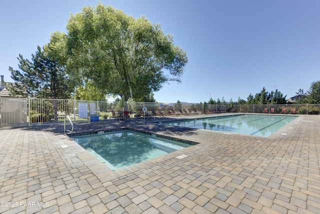 community pool with a patio and fence