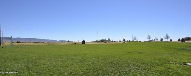 view of yard with a rural view and a mountain view