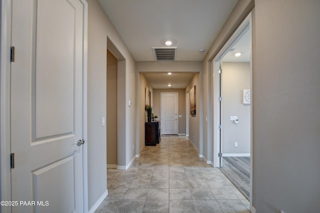 corridor featuring visible vents and baseboards