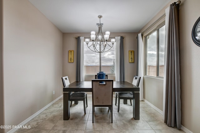 dining space featuring baseboards and a notable chandelier