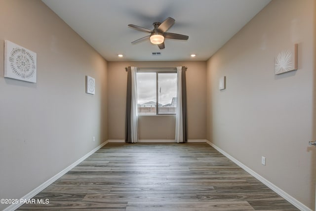 spare room with visible vents, wood finished floors, recessed lighting, baseboards, and ceiling fan