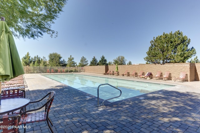 community pool featuring a patio and fence