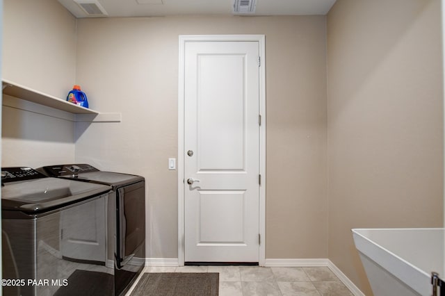 clothes washing area with laundry area, baseboards, visible vents, and washing machine and clothes dryer