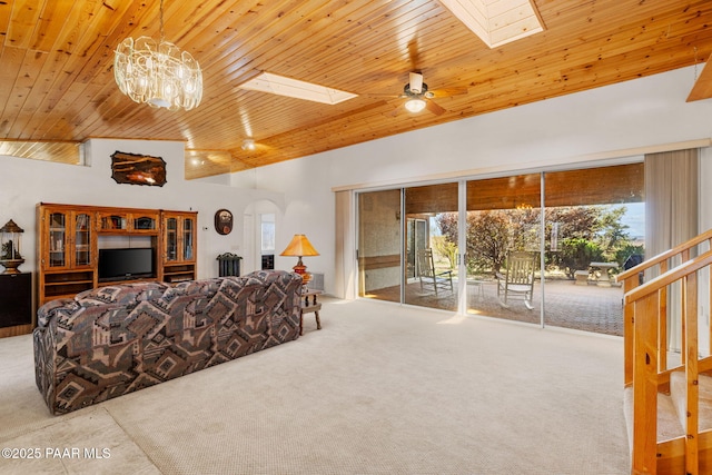 carpeted living room with wooden ceiling, ceiling fan, a high ceiling, and a skylight