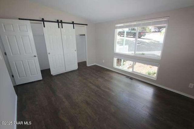 487 Stewart Cir, Prescott, AZ 86301 - unfurnished bedroom with lofted ceiling, dark wood finished floors, baseboards, and a barn door