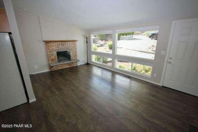 487 Stewart Cir, Prescott, AZ 86301 - unfurnished living room with wood finished floors, a brick fireplace, baseboards, and lofted ceiling