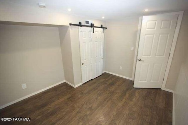 487 Stewart Cir, Prescott, AZ 86301 - unfurnished bedroom featuring a barn door, baseboards, wood finished floors, recessed lighting, and a closet