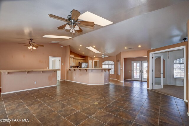 9100 E Lonesome Valley Rd, Prescott Valley, AZ 86315 - unfurnished living room with french doors, a ceiling fan, and lofted ceiling with skylight