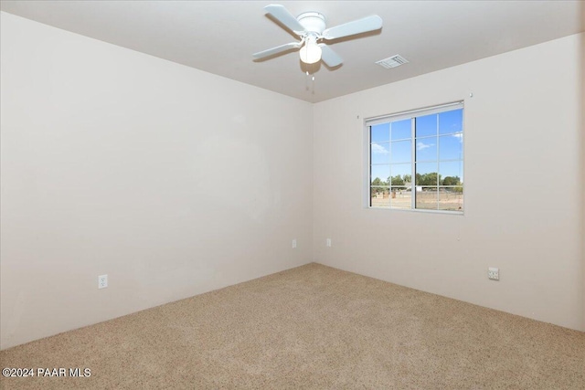 carpeted spare room featuring ceiling fan