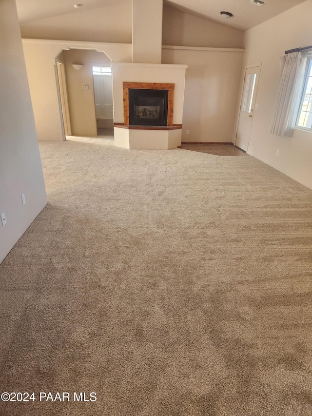 unfurnished living room featuring carpet floors and lofted ceiling