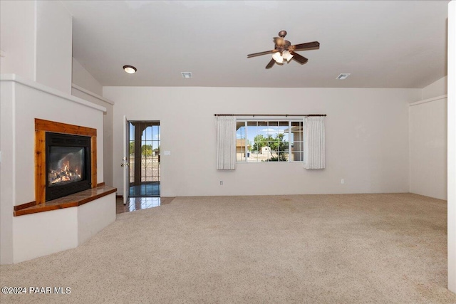 unfurnished living room with carpet and ceiling fan