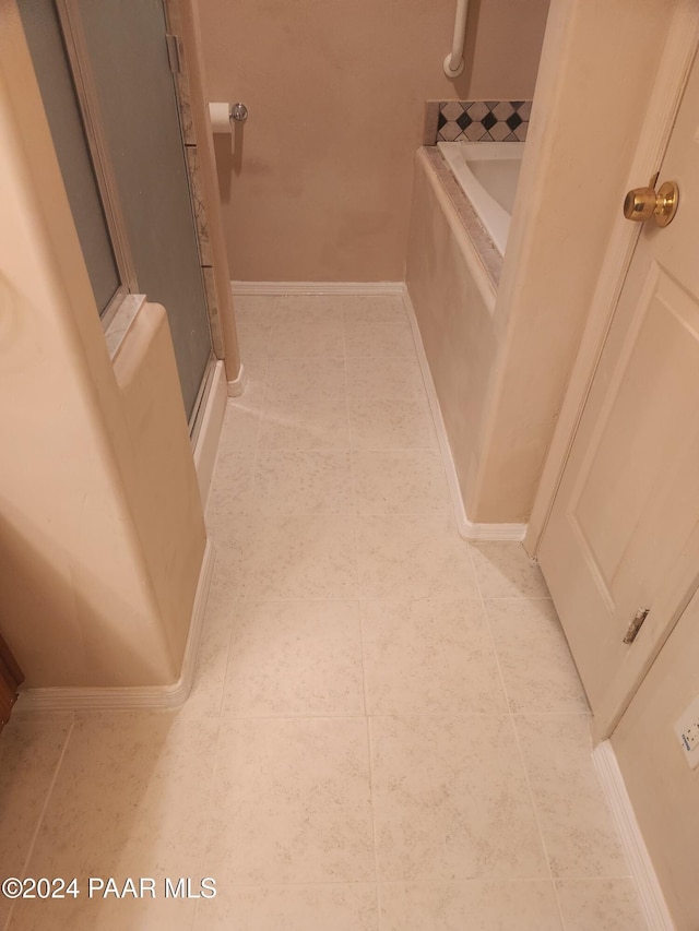 bathroom with tile patterned floors and shower with separate bathtub