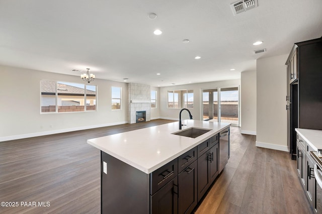 kitchen with a wealth of natural light, sink, stainless steel dishwasher, and a center island with sink