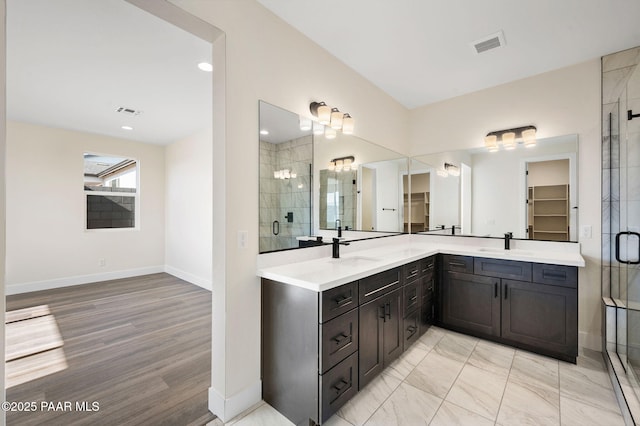 bathroom with hardwood / wood-style floors, vanity, and a shower with shower door