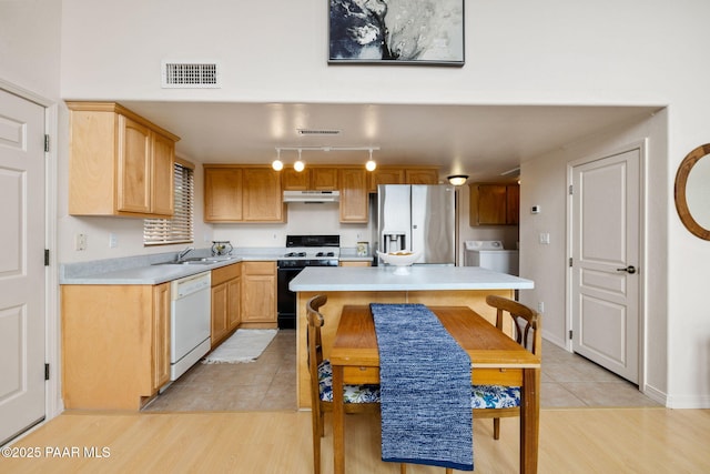 kitchen with gas stove, visible vents, stainless steel fridge with ice dispenser, white dishwasher, and under cabinet range hood