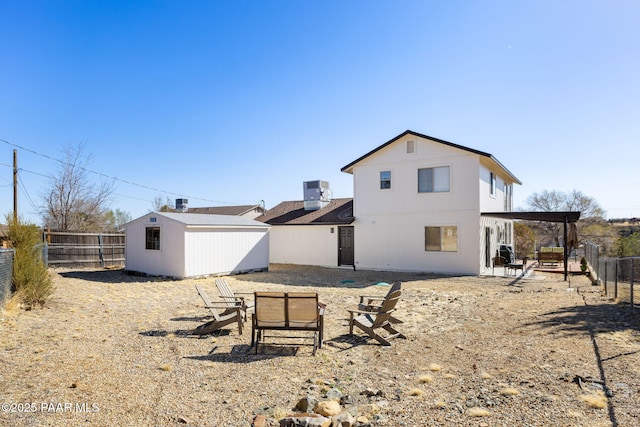 rear view of property featuring an outbuilding, central air condition unit, a patio area, and a fenced backyard