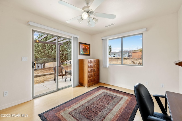 office space with visible vents, baseboards, wood finished floors, and a ceiling fan