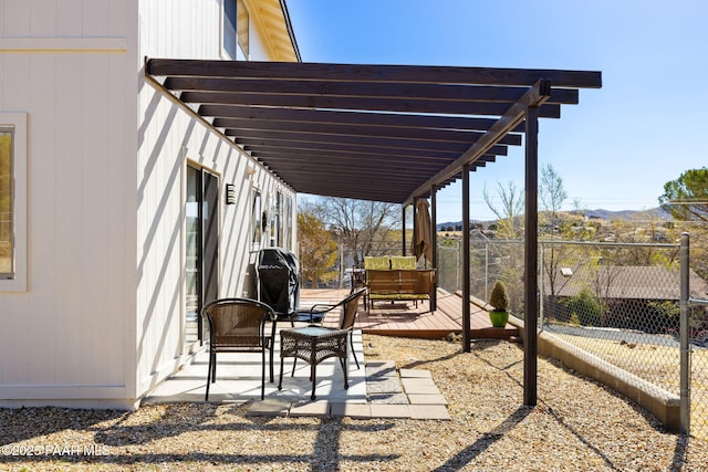 view of patio / terrace featuring a wooden deck and fence