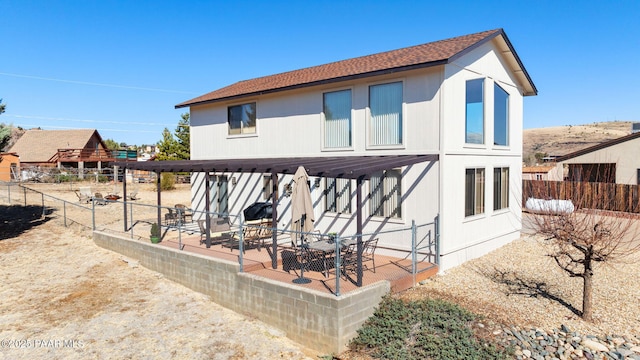 back of property featuring a patio, roof with shingles, and fence